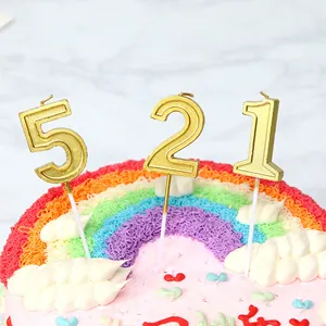Velas de cumpleaños doradas 521 sobre un pastel arcoíris para celebración de fiestas