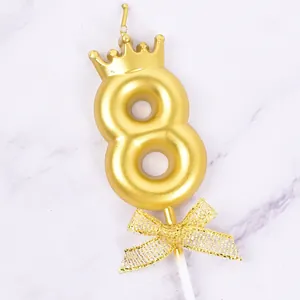 Elegant golden number 8 birthday candle featuring a crown top and a glittery gold bow