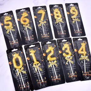 Detailed view of golden crown number candles 0-9 in elegant black gift packaging