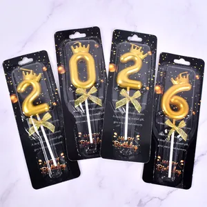 Detailed view of luxury golden number candles 2, 0, 6 with crown and bow decorations.