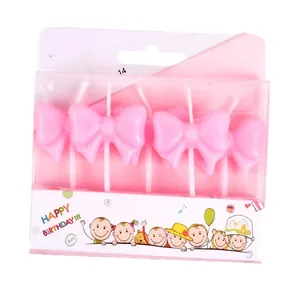 Pack of pink bow-shaped birthday candles for cake decoration and birthday parties