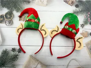 Vista detallada de dos diademas de elfo navideño con orejas y cascabeles sobre madera