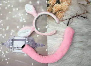 Close-up view of pink plush animal ear headband and matching tail set for Halloween costumes