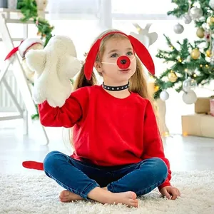Fillette en costume de renne de Noël rouge avec oreilles et nez près d'un sapin décoré