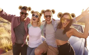Group of happy friends wearing cute plush bear ear headbands in outdoor sunny setting