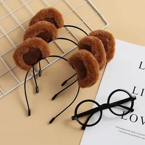 Close-up detail of plush bear ears on brown headbands set against aesthetic background props.
