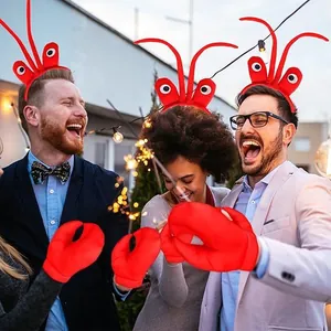 Happy friends wearing red lobster claw headbands and gloves at a festive rooftop party.