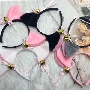 Macro view of various plush cat ear headbands with ribbons and bells on white fur.