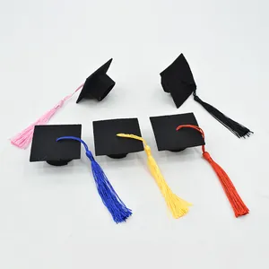 Macro view of miniature black graduation caps with various colorful silk tassels.