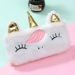 Gros plan d'une trousse licorne en peluche blanche avec corne dorée et texture douce