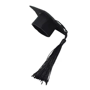 Close-up macro detail of a miniature black felt graduation cap with a matching black tassel
