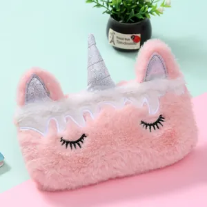 Gros plan d'une trousse licorne en peluche rose avec corne pailletée