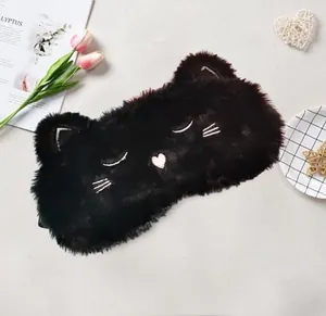 Close-up detail of the cute black plush cat-shaped sleep mask with soft faux fur texture.