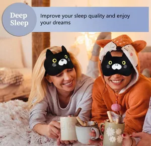 Two smiling women wearing cute black cat plush sleep eye masks in a cozy bedroom scene