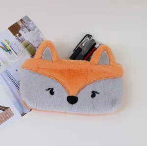 Gros plan d'une jolie trousse à crayons en peluche renard orange et gris avec des stylos.