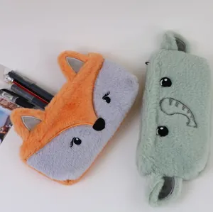 Gros plan de trousses en peluche mignonnes en forme de renard et dinosaure pour élèves