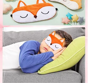 Close-up view of a child wearing a cute plush orange fox sleep mask while napping on a sofa