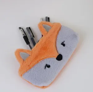 Gros plan d'une trousse en peluche renard contenant plusieurs stylos