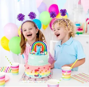 Happy kids wearing purple pom-pom headbands at a rainbow birthday party celebration