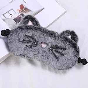 Close-up detail of a cute grey plush cat-themed sleep eye mask with soft pink details
