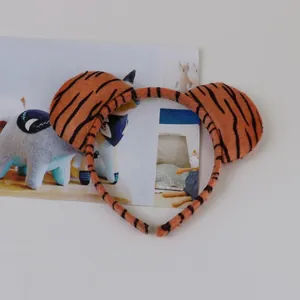 Detailed macro view of the plush texture and stripe pattern on the tiger ear headband.