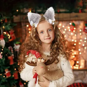 Detail view of furry cat ears headband with white bows and golden bells worn by a child