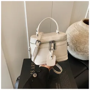 Gros plan sur un sac boîte blanc crème minimaliste avec poignée et bandoulière