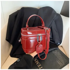 Vue détaillée d'un sac à main boîte rouge vif avec des fermetures éclair en argent.
