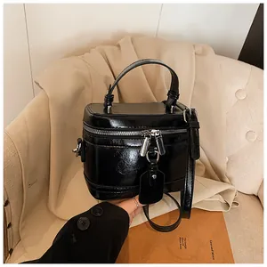 Sac à main boîte noir minimaliste élégant avec doubles fermetures éclair et poignée.