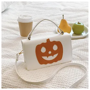 Stylish white Halloween handbag with orange pumpkin detail shown in a cozy home setting