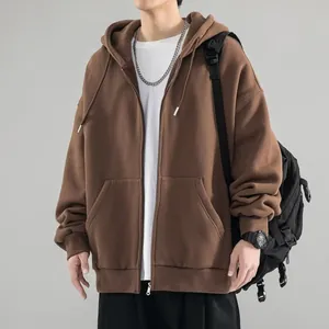 Detailed view of a brown oversized zip-up hoodie featuring a plastic zipper and pockets.