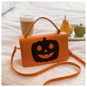 Close-up of a vibrant orange Halloween pumpkin handbag with a smiling face design.