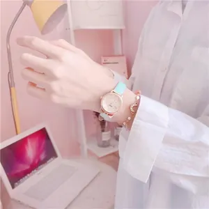 Close-up of a girl's watch with light blue leather strap and rose gold cat-ear case.