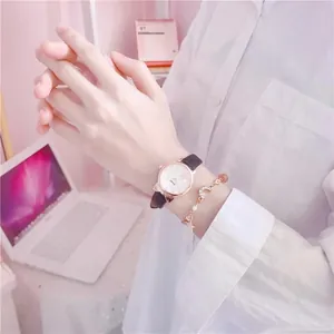 Close-up of a stylish gold girls watch paired with a star charm bracelet on a wrist