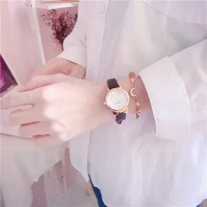Detail view of a cute girls' kitten ear watch and moon charm bracelet set on a wrist