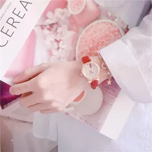 Close-up of a stylish red cat-ear watch with a star bracelet on a girl's wrist