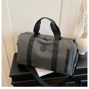 Close-up of grey large capacity travel gym bag placed on a black cabinet with decor