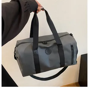 Hand-held view of grey large capacity gym bag with durable black straps and side pocket