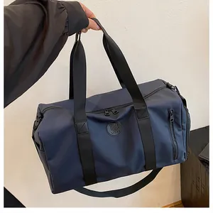 Close-up of a navy blue large capacity travel bag held by hand, showing its sleek design.