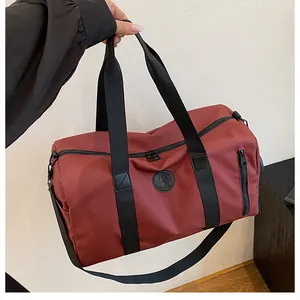 Close-up of a large capacity maroon travel gym bag featuring durable black handles