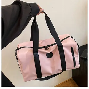 Detailed view of a pink large capacity fitness duffel bag featuring sturdy black straps.
