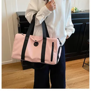 Close-up of a pink gym bag with wet/dry separation being carried on the shoulder of a person