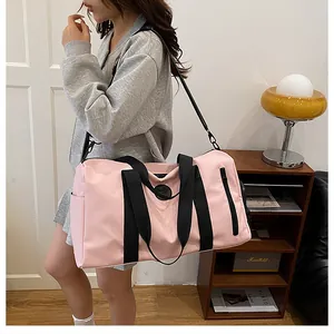 Detailed view of the large pink gym travel bag carried by a model in a cozy room.