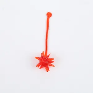 Close-up of an orange sticky meteor hammer toy with a spiked ball and long tail.