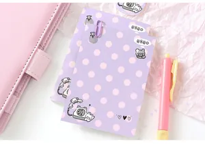 Detailed view of purple polka dot memo pad with cute cartoon bear and phone illustration