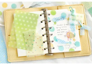 Detailed macro shot of translucent vellum paper stickers with colorful dots for journaling decor