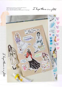 Close-up of hand-drawn watercolor girl stickers on a journal page with creative artistic props