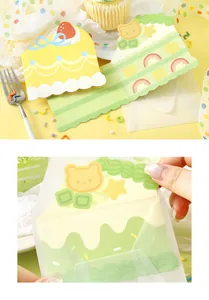 Detailed view of a cute cake-shaped greeting card being tucked into a translucent envelope.