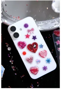 Dettaglio di adesivi 3D in resina glitterata su una custodia per telefono bianca