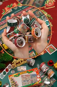 Detailed view of 18 vintage Christmas washi tapes held in hands with festive decorations
